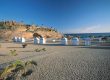 Arena, pasarela y casetas junto al mar en Playa del Duque